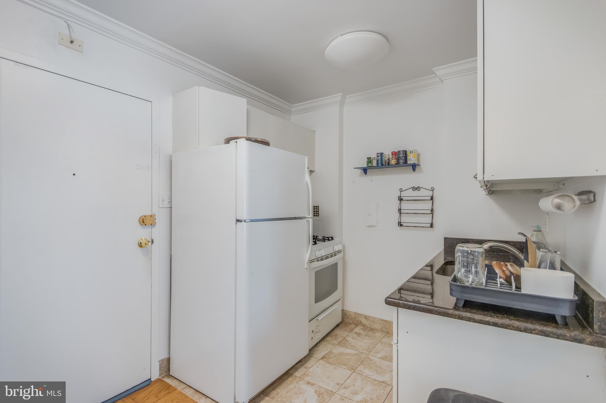 922 24th Street Northwest, Unit 415 Washington, DC 20037 - Photo 2 of 25 a white refrigerator freezer and a stove sitting inside of a kitchen