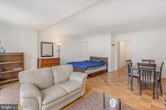 a living room with furniture and a dining table with wooden floor