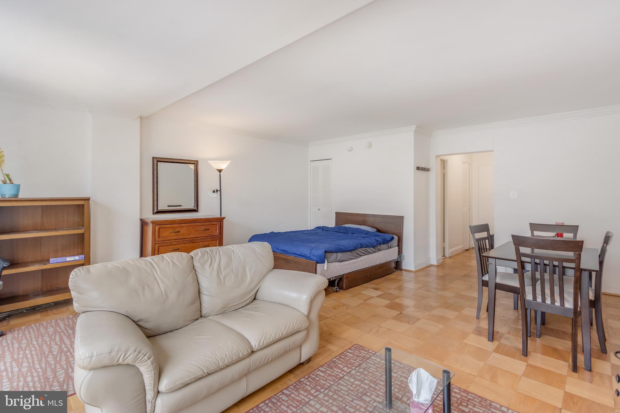 922 24th Street Northwest, Unit 415 Washington, DC 20037 - Photo 10 of 25 a living room with furniture and a dining table with wooden floor