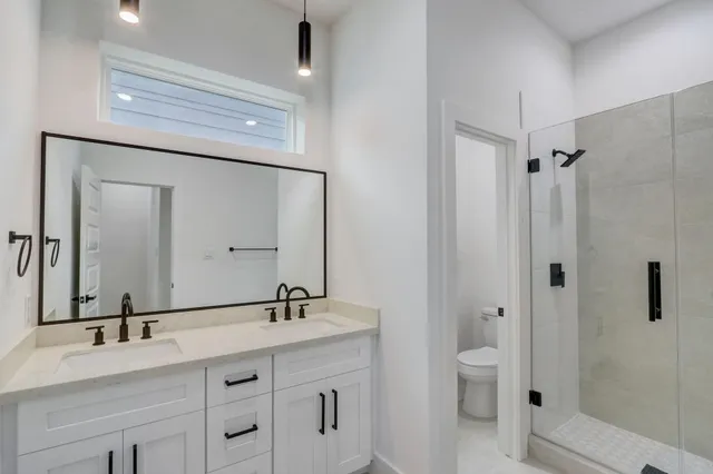 a bathroom with a double vanity sink mirror and shower