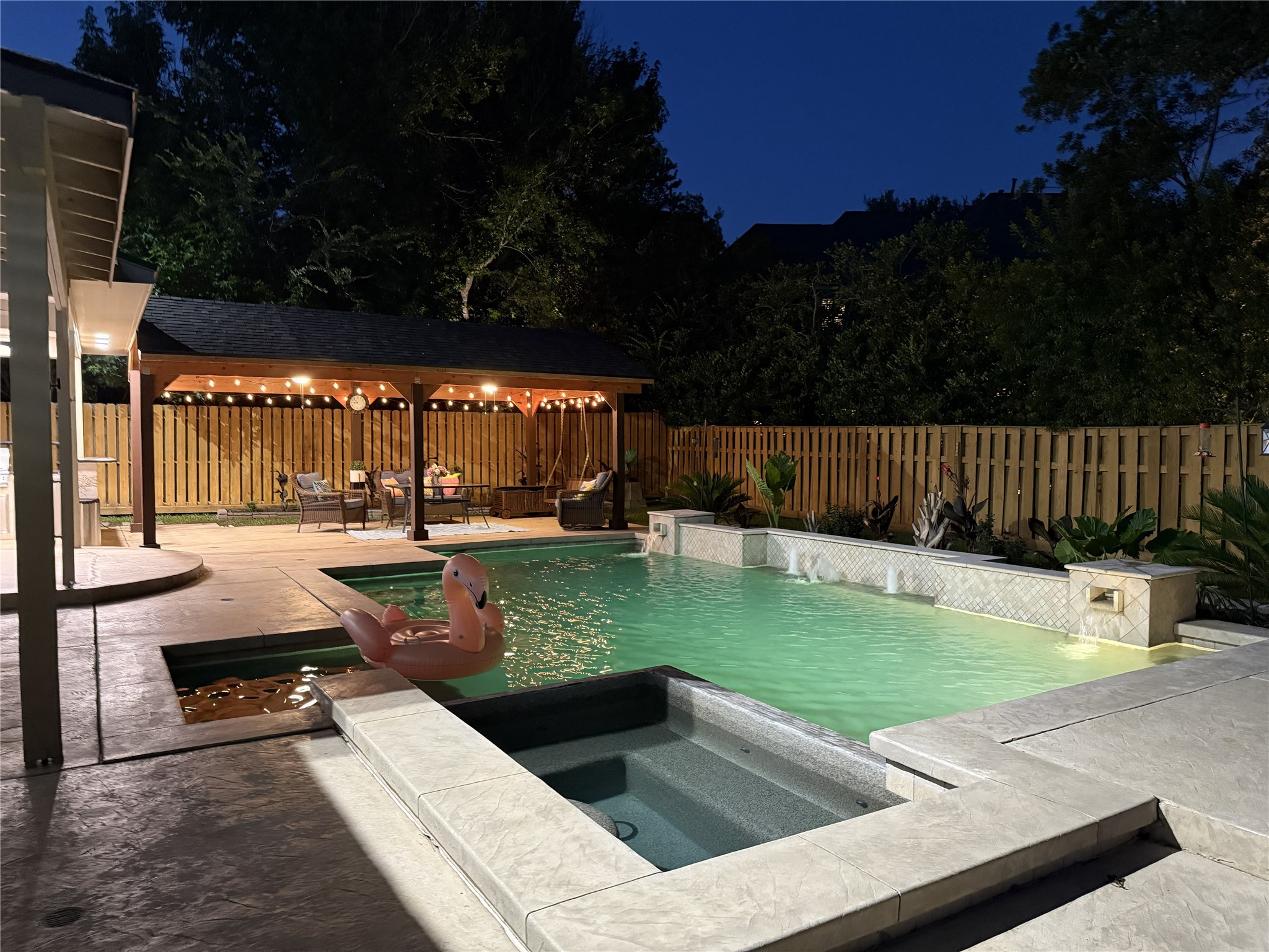 15 West Beckonvale Circle The Woodlands, TX 77382 - Photo 41 of 44 As dusk settles in, the sparkling pool and spa reflect the home’s elegant architecture and refined style. Whether hosting guests or unwinding after a long day, this inviting outdoor retreat offers a seamless blend of ambiance, comfort, and evening serenity.