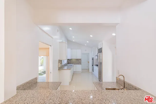 a large white kitchen with stainless steel appliances