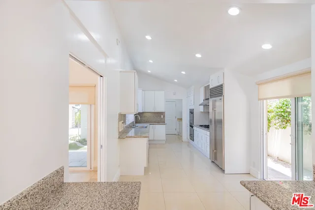 a open kitchen with white cabinets and stainless steel appliances