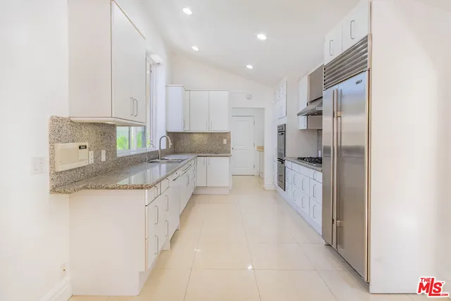 a kitchen with a sink window and cabinets