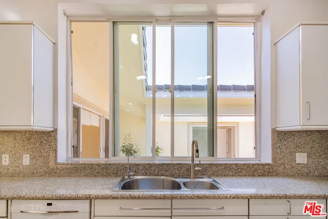 a kitchen with granite countertop white cabinets and a sink