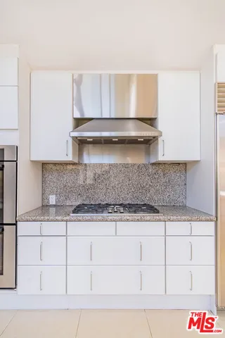 a large kitchen with a large window and stainless steel appliances