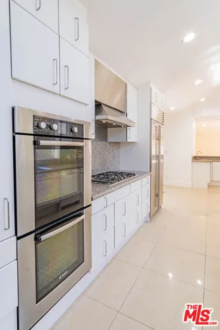 a bathroom with a granite countertop sink and a large mirror