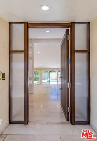 a view of a hallway with wooden floor and a living room