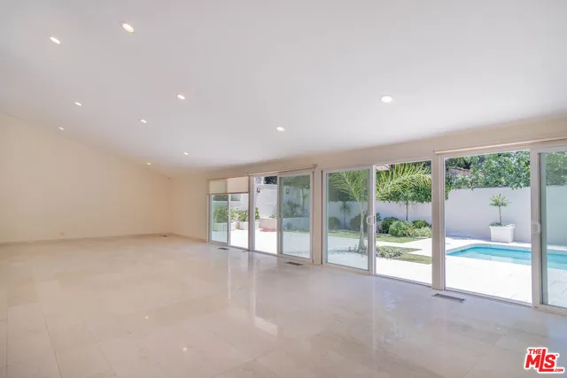 a view of an empty room with wooden floor and a fireplace