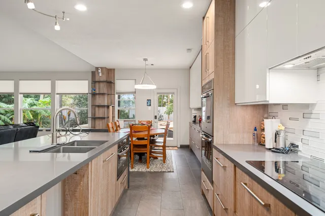 a kitchen with sink a counter top space and living room view
