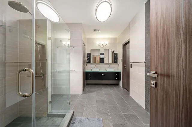 a bathroom with a double vanity sink a mirror and shower