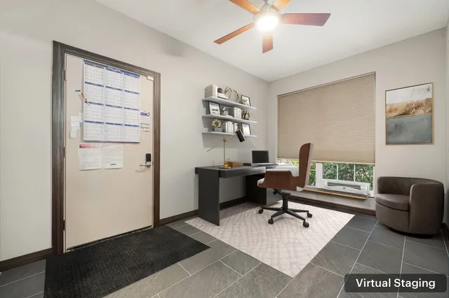 a view of a workspace with furniture and a window