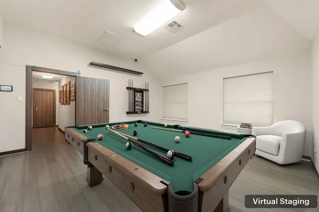 a room with furniture pool table and window