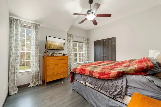 a bedroom with a bed and flat tv screen on the dresser