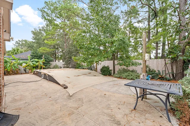 a view of a backyard with a bench and some trees