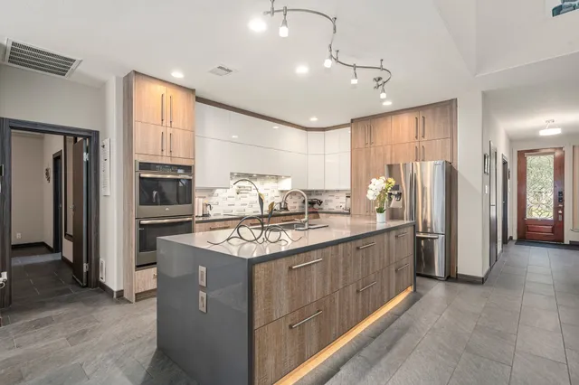a kitchen with stainless steel appliances granite countertop a sink stove and refrigerator
