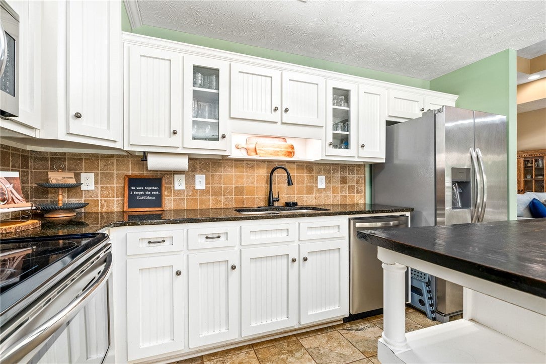 This bright kitchen features granite counters and stainless steel appliances.