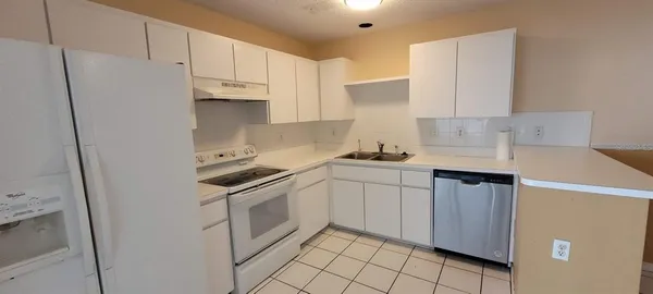 a kitchen with stainless steel appliances white cabinets and a refrigerator