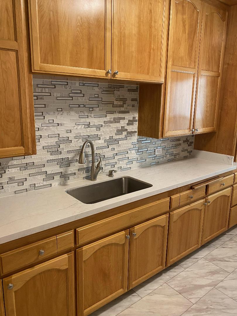 a kitchen with stainless steel appliances granite countertop a sink and a white cabinets