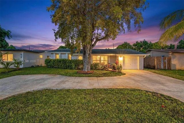 a view of a house with a yard and potted plants