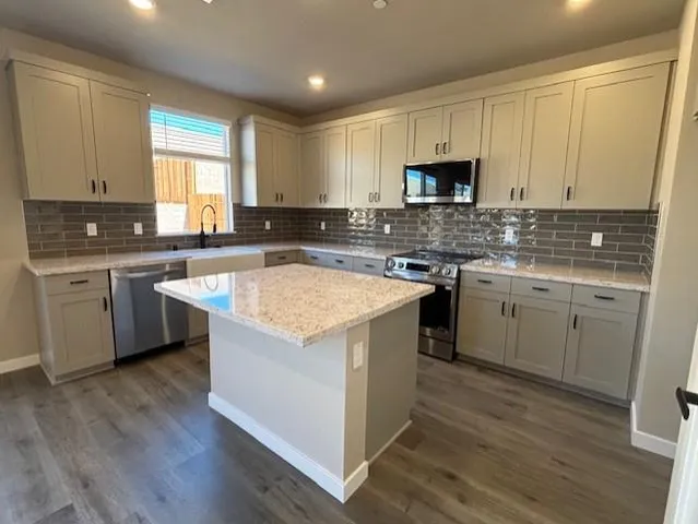 a kitchen with a sink cabinets and wooden floor