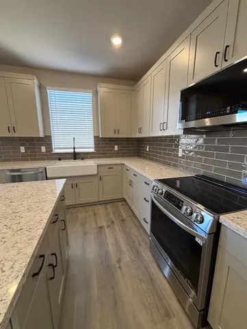 a kitchen with a stove a sink and a microwave