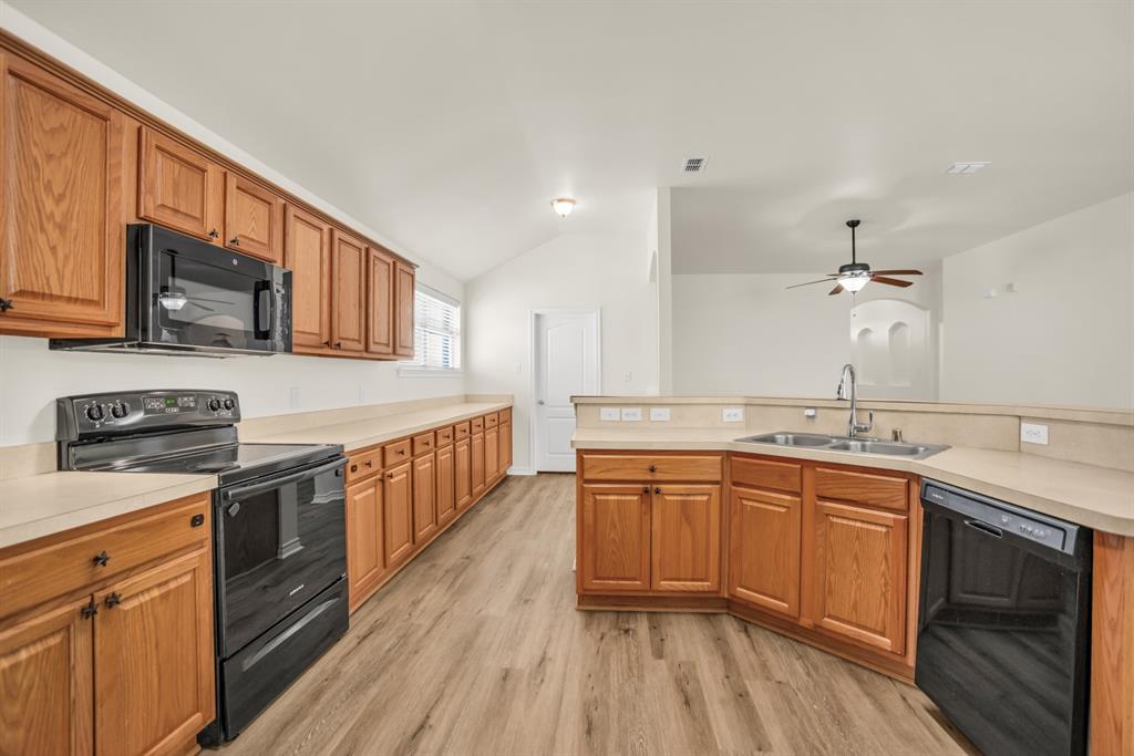 2005 Ridgeview Court Sanger, TX 76266 - Photo 4 of 20 a kitchen with stainless steel appliances granite countertop a sink stove cabinets and wooden floor