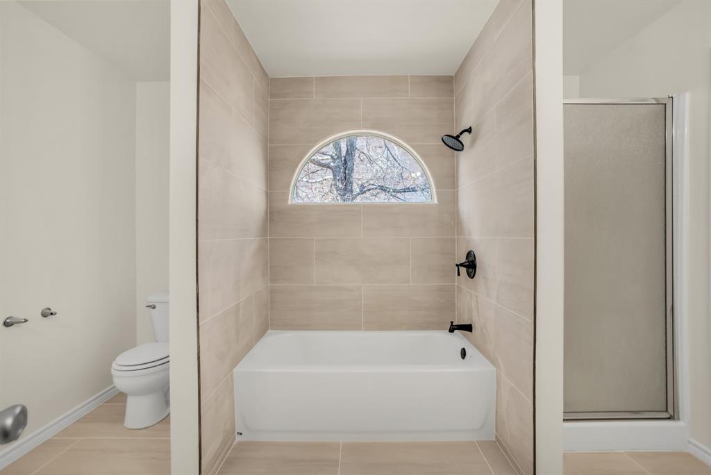 2005 Ridgeview Court Sanger, TX 76266 - Photo 8 of 20 a bathroom with a bathtub and a toilet