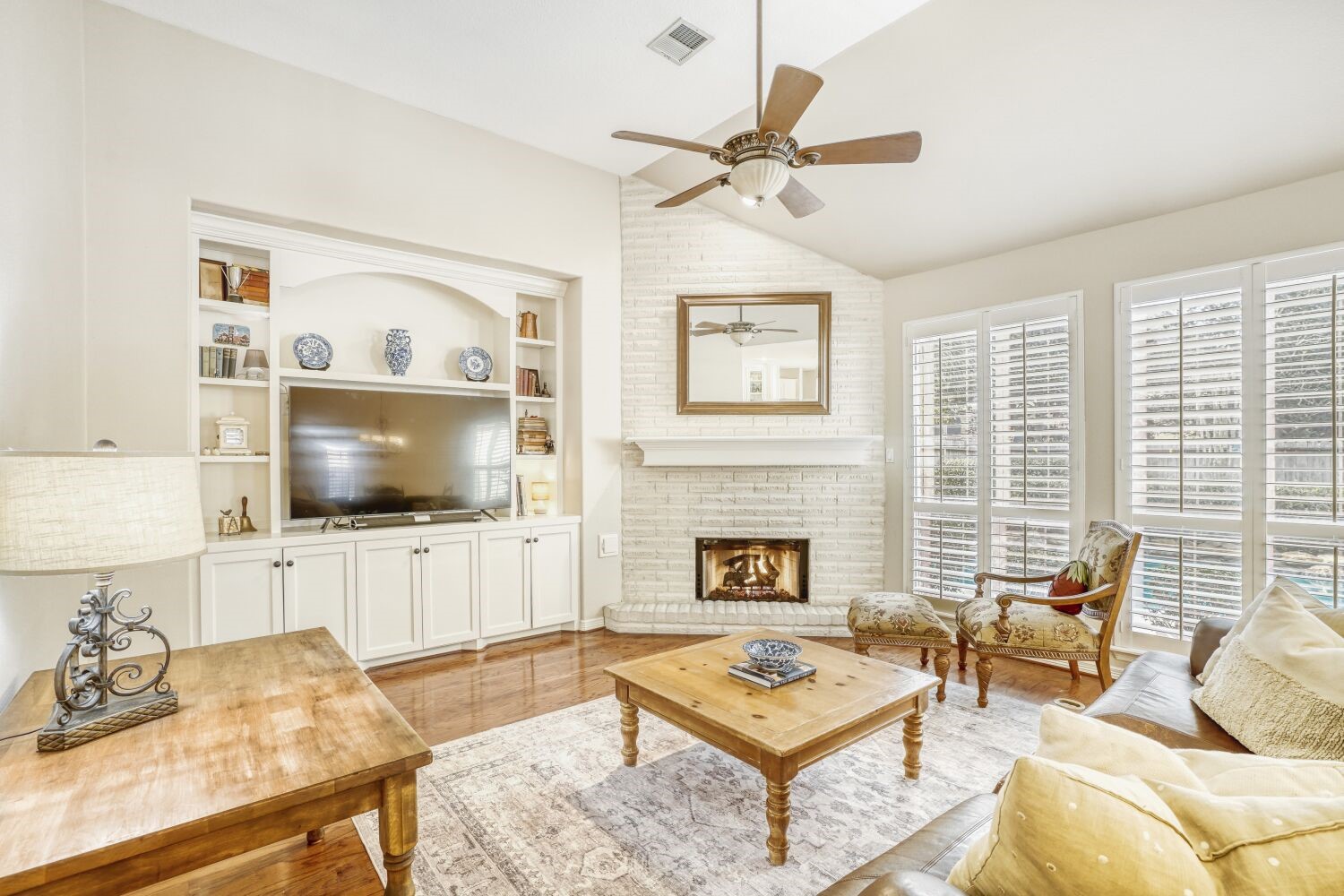 5308 Mountain Grove Court Spring, TX 77379 - Photo 7 of 31 This cozy living room features a white brick fireplace, built-in shelving, and large windows with shutters that allow plenty of natural light.