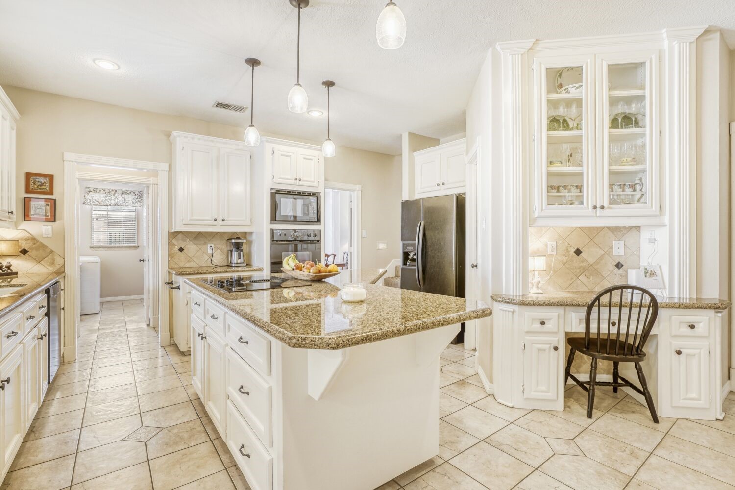 5308 Mountain Grove Court Spring, TX 77379 - Photo 10 of 31 Bright kitchen filled with natural light, featuring granite countertops, white cabinetry, and modern appliances. A central island with pendant lighting, including a convenient desk nook and a large pantry to add both functionality and style.
