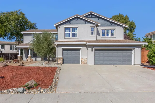 a front view of a house with yard and trees