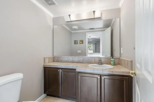 a bathroom with a granite countertop sink a toilet and a mirror