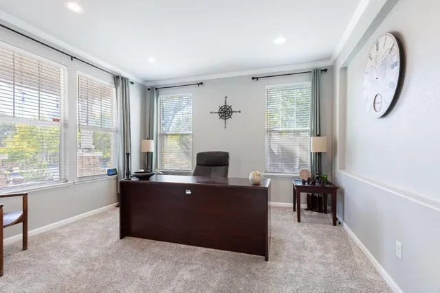 a view of a workspace with furniture and a window