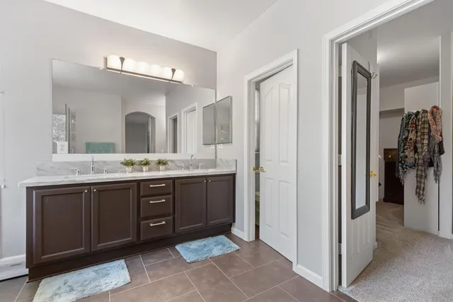 a spacious bathroom with a granite countertop sink and a mirror
