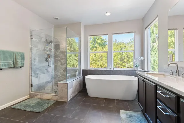 a spacious bathroom with a tub shower and window