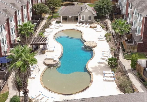 an aerial view of a house with swimming pool and outdoor seating