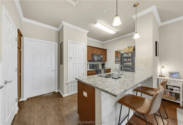 a kitchen with granite countertop kitchen island stainless steel appliances microwave cabinets dining table and chairs