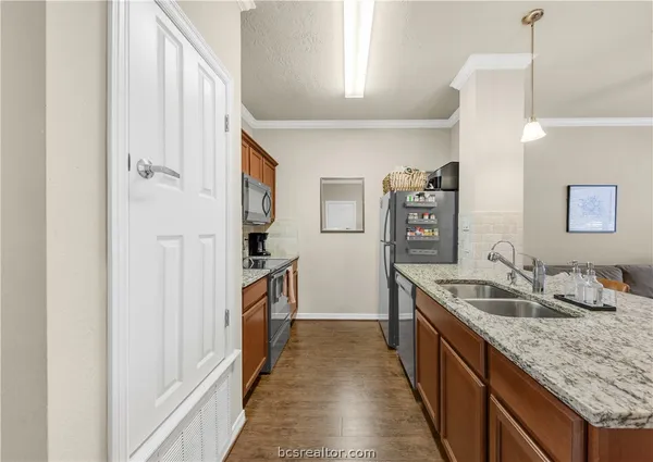 a kitchen with stainless steel appliances granite countertop a sink and a refrigerator