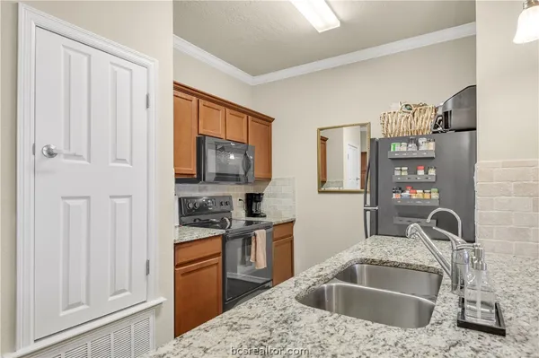 a kitchen with stainless steel appliances granite countertop a sink stove and refrigerator