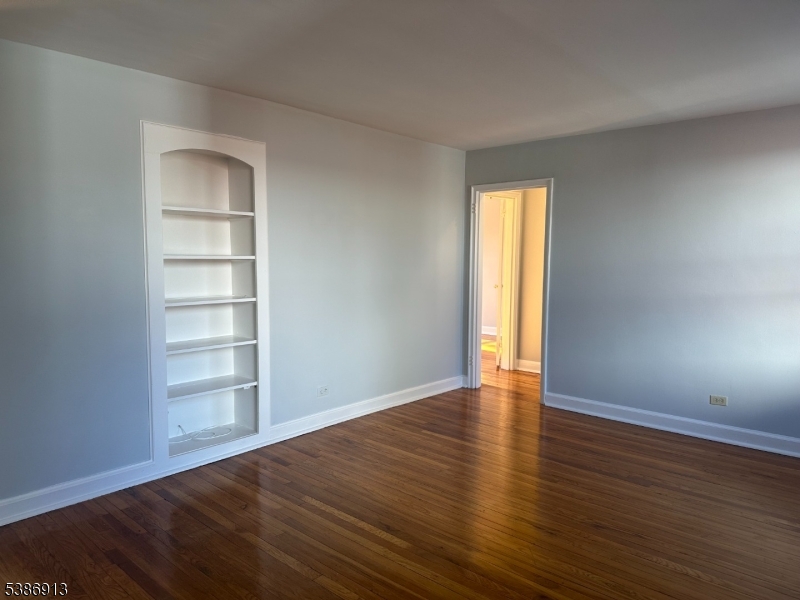 160 Gordonhurst Avenue, Unit E2 Montclair, NJ 07043 - Photo 2 of 3 a view of an empty room with a window and wooden floor