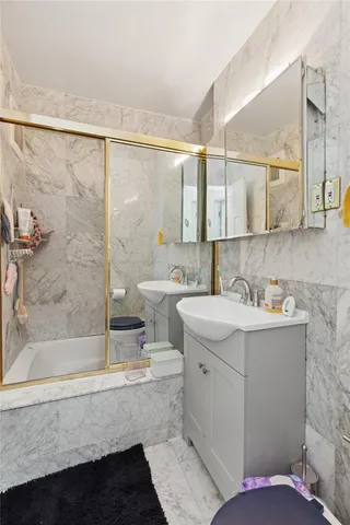 a bathroom with a double vanity sink mirror and bathtub