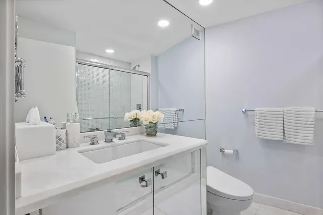 a bathroom with a sink a toilet and a mirror