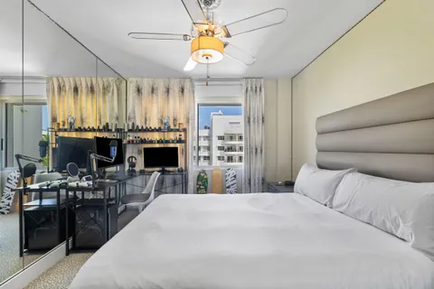 a bed room with a bed mirror and a chandelier