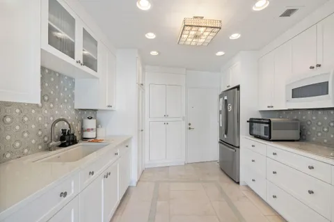 a kitchen with granite countertop a refrigerator and a sink