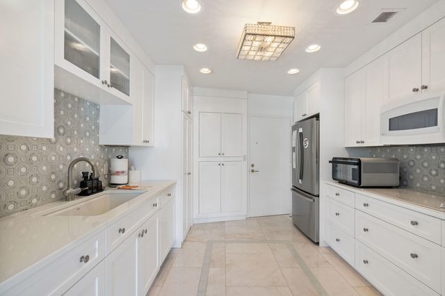 a kitchen with granite countertop a refrigerator and a sink