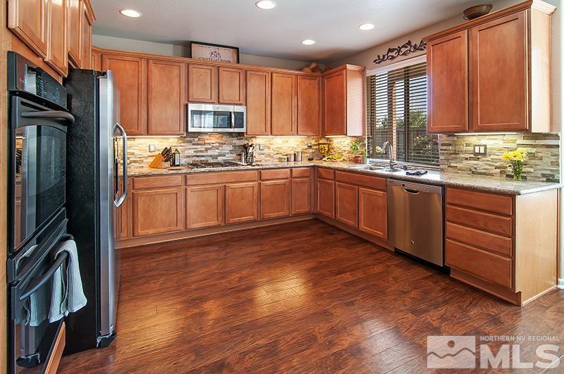 585 Magistrate Court Reno, NV 89521 - Photo 6 of 22 a kitchen with granite countertop wooden floors stainless steel appliances and cabinets