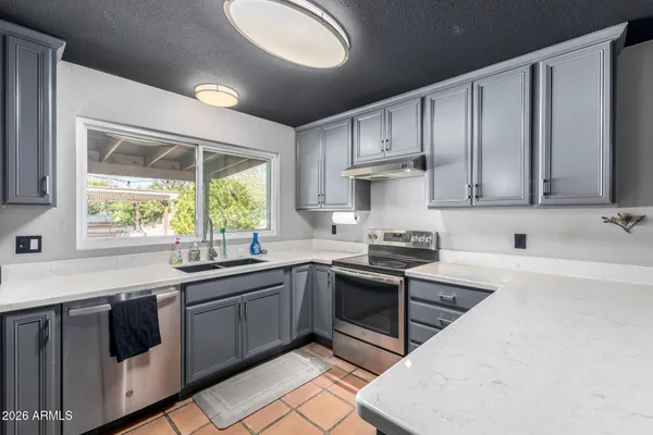 a large kitchen with kitchen island a sink stainless steel appliances and cabinets