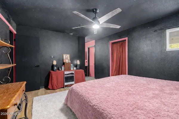 a bedroom with a bed and a lamp on dresser