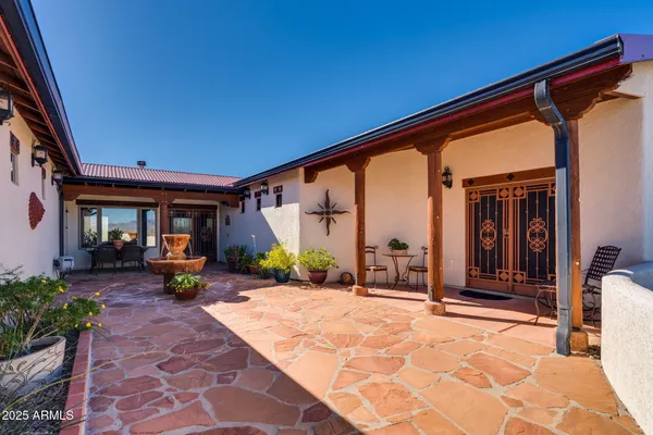 a kitchen with stainless steel appliances granite countertop a refrigerator a sink dishwasher a dining table and chairs with wooden floor