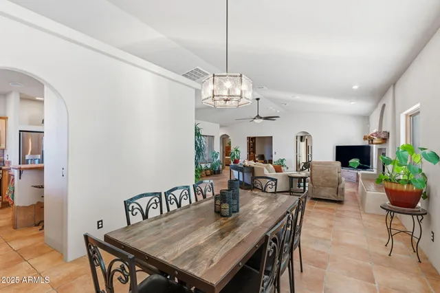 a backyard of a house with sofas table and chairs